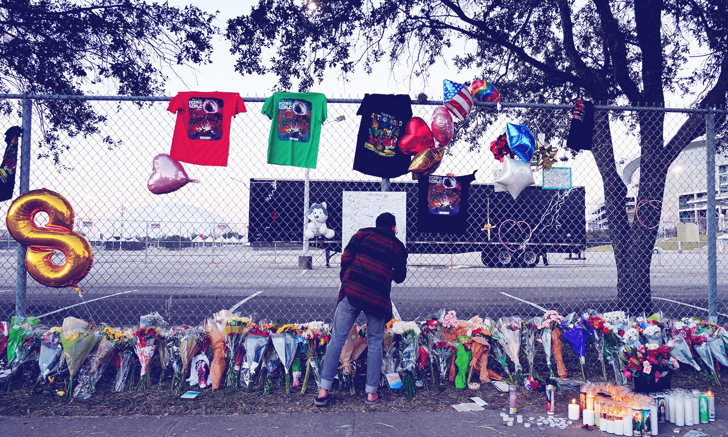 A VISITOR WRITES A NOTE AT A MEMORIAL OUTSIDE OF THE CANCELED ASTROWORLD FESTIVAL AT NRG PARK IN HOUSTON, TEXAS