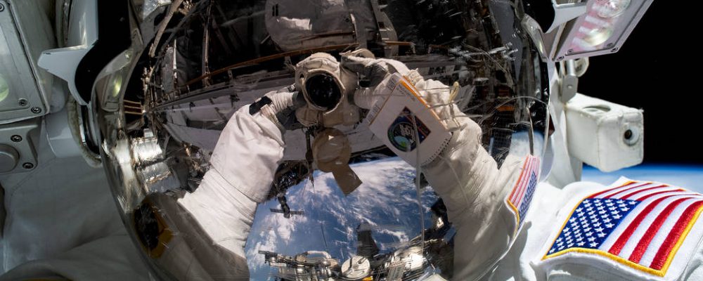 REFLECTION OF SPACE ON SPACE HELMET DURING IMMERSIVE EXPERIENCE CALLED THE INFINITE