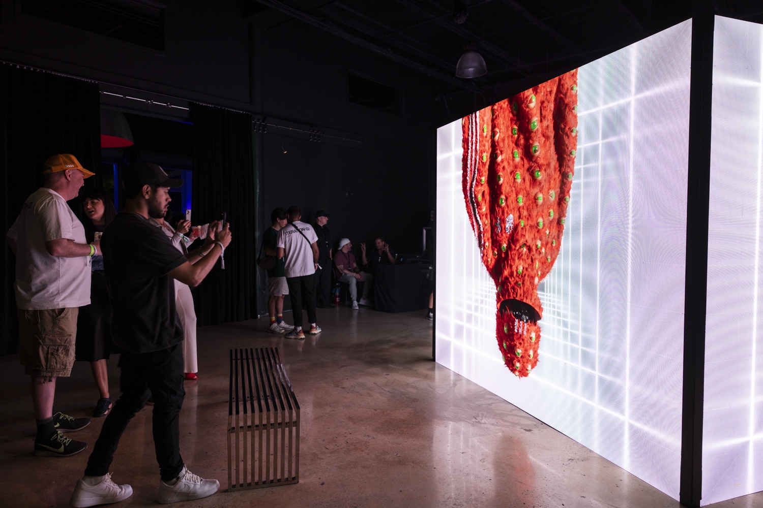 MAN TAKING PHOTO OF ADIDAS VIRTUAL GEAR EXHIBITION CALLED (PROBABLY) REAL MIAMI