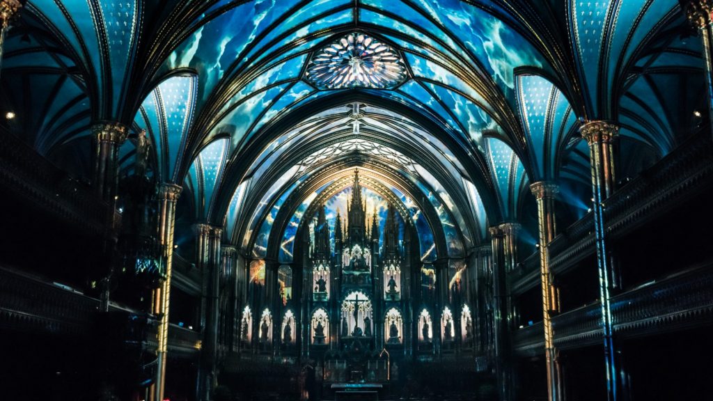 BLUE AND GREEN INTERIOR OF THE NOTRE DAME BASILICA IN MONTREAL FOR MOMENT FACTORY’S AURA AT THE NOTRE DAME BASILLICA